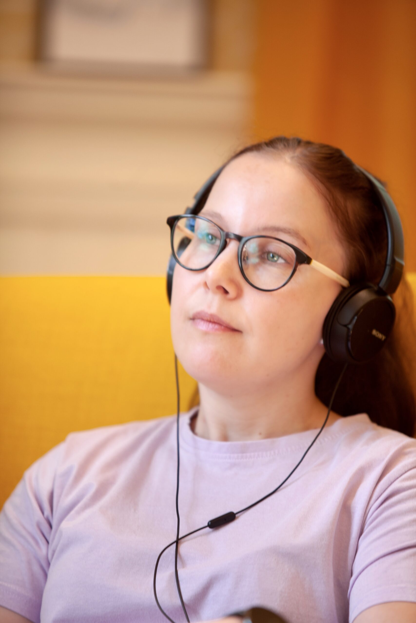 Nainen kuuntelee kuulokkeilla
